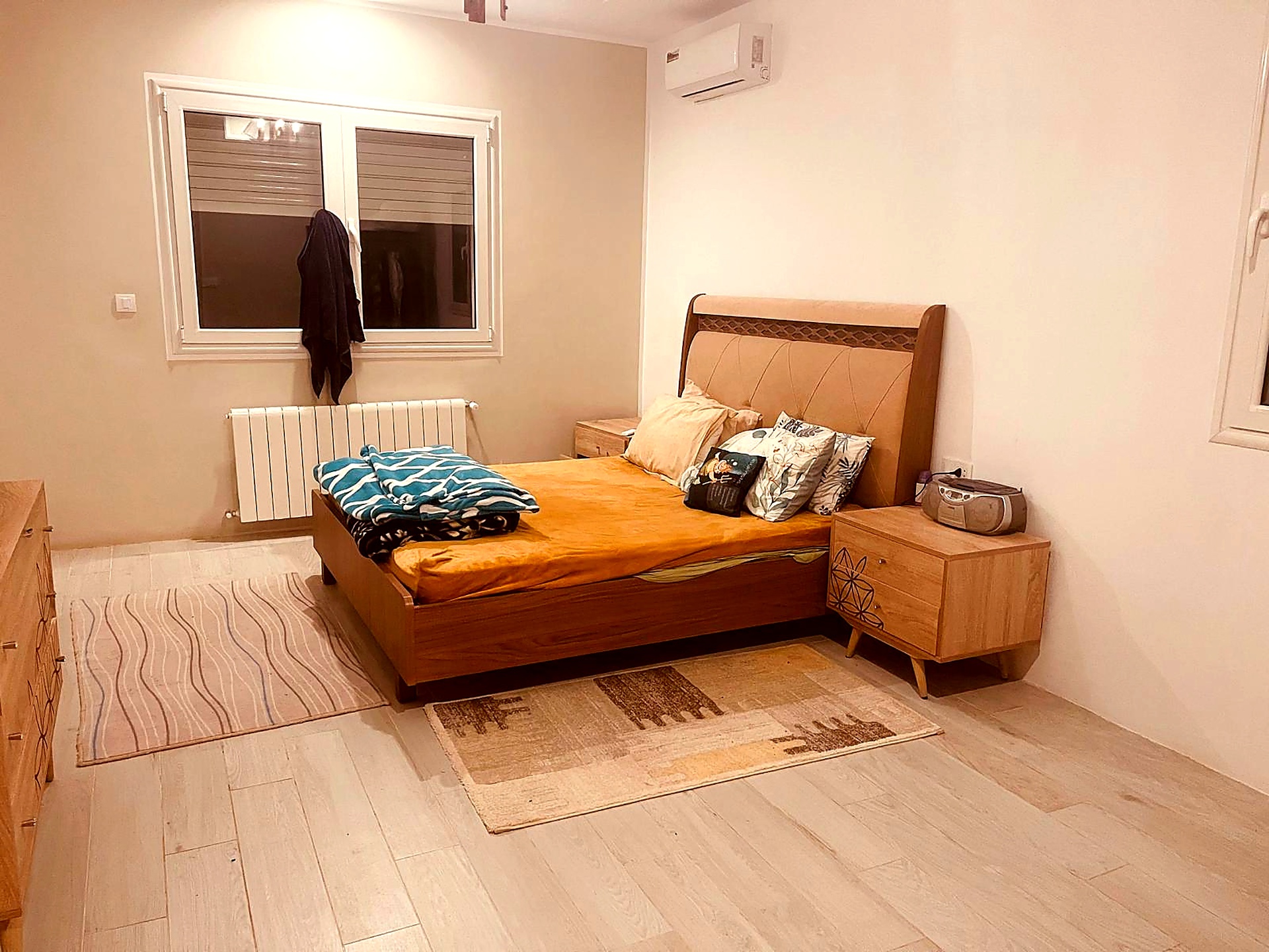 Bedroom with wooden bed, air conditioning and large window