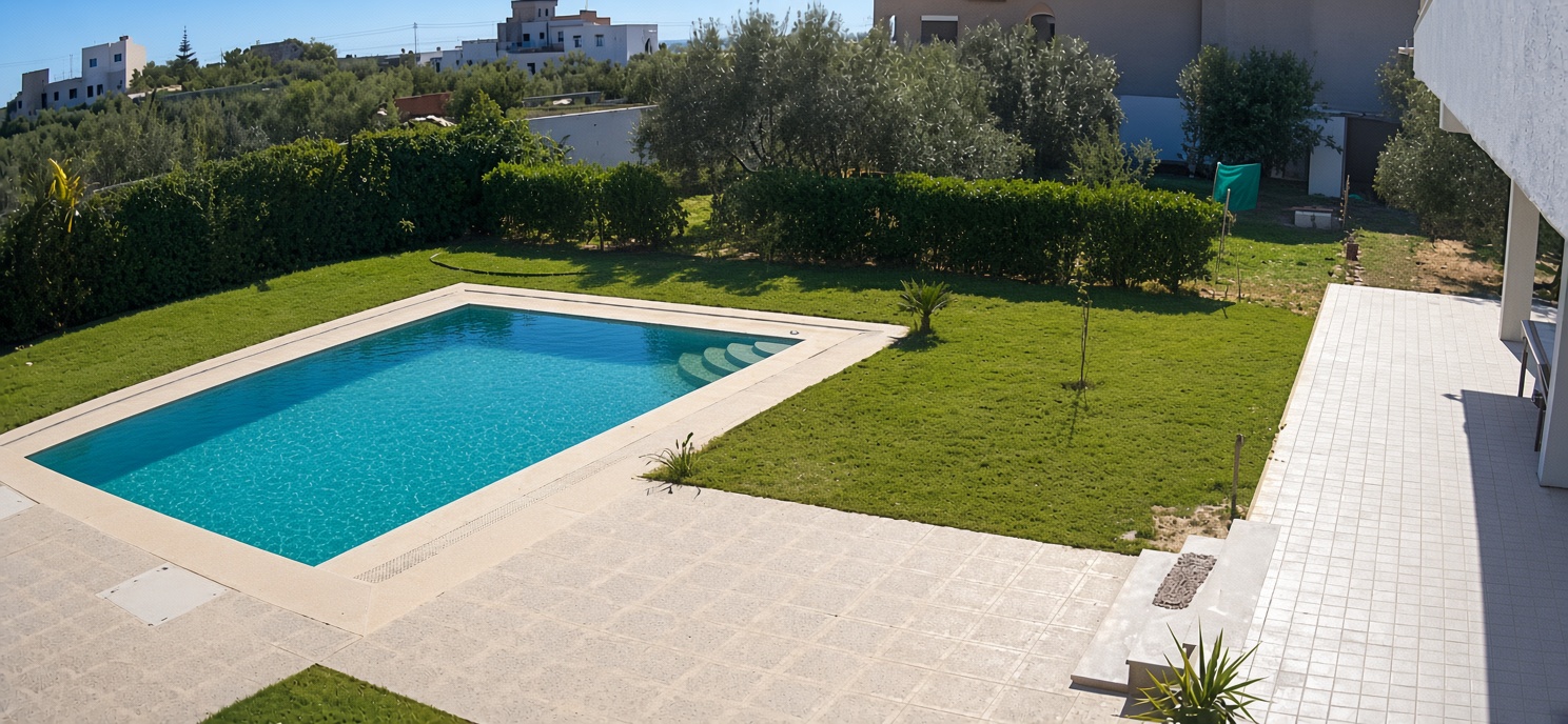 Swimming pool, lawn and hedged garden seen from the upper floor