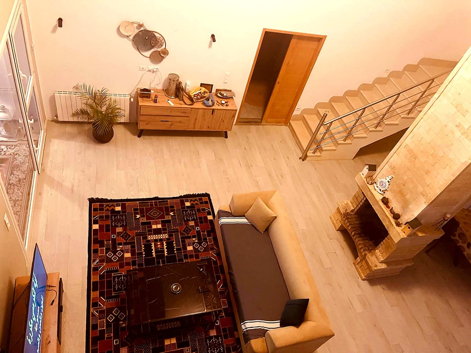 Living room seen from the mezzanine with Berber rug and fireplace