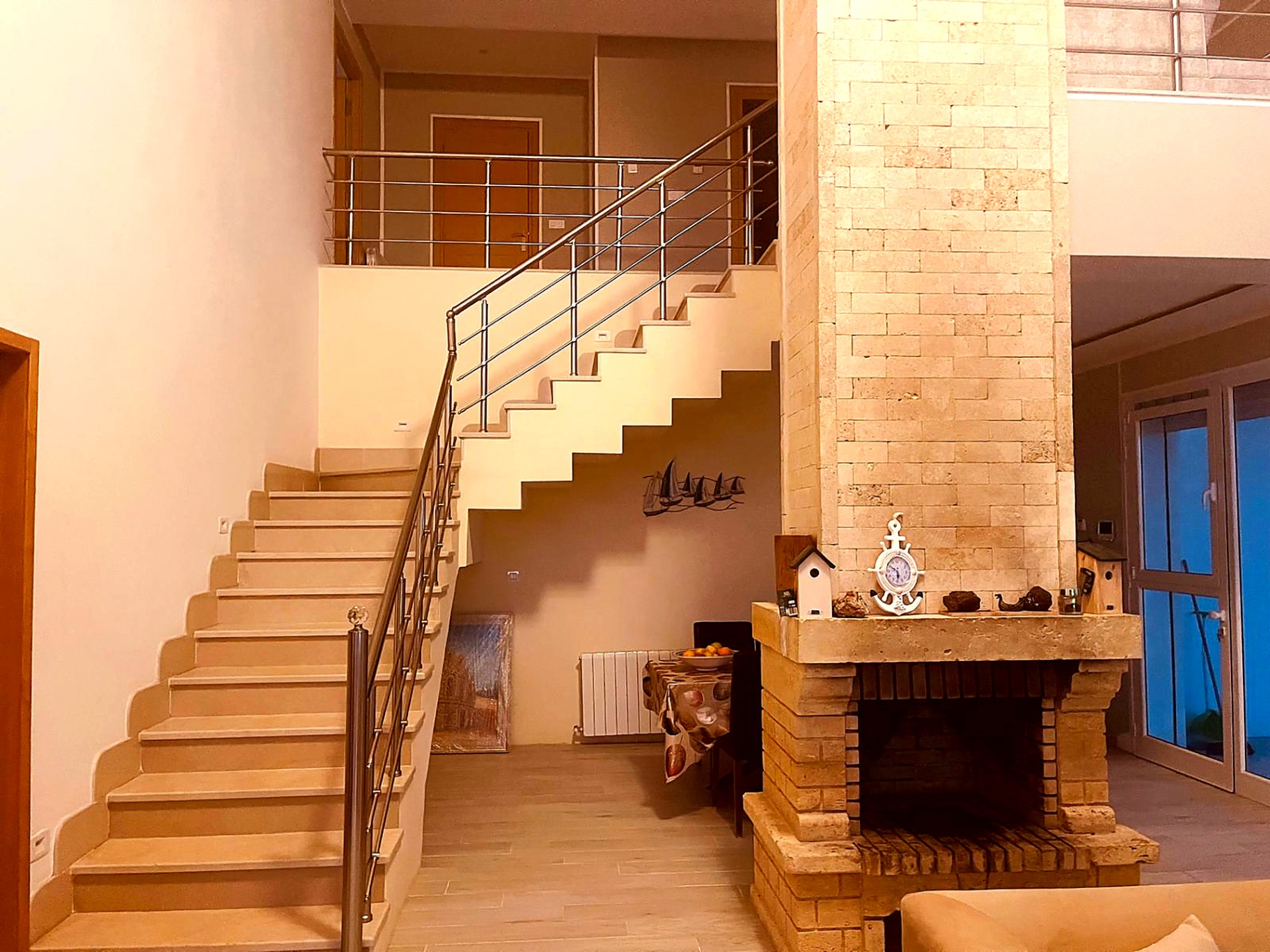 Grand salon with stone fireplace and open staircase