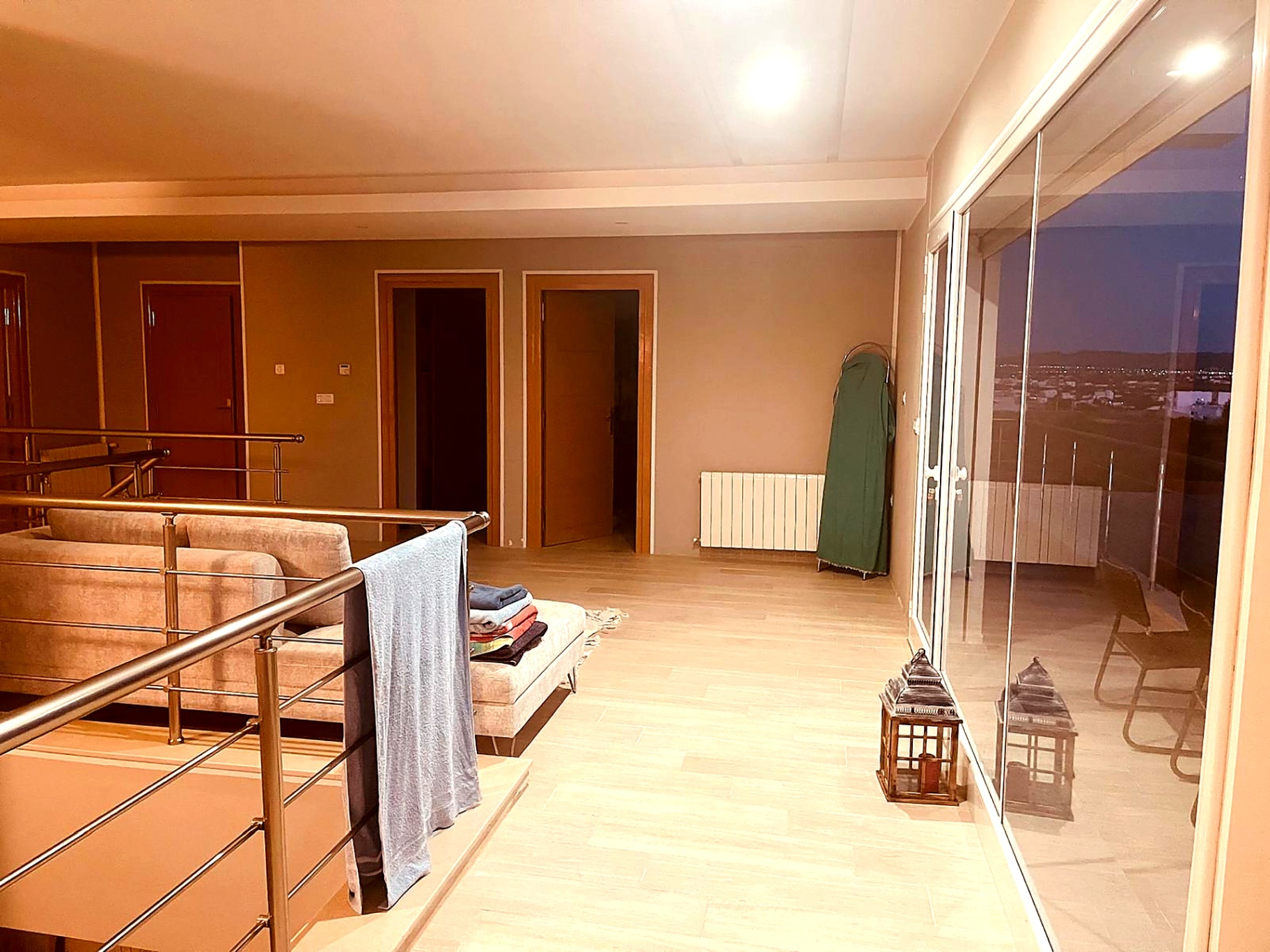 Upper floor lounge at night with panoramic glazing over the town lights