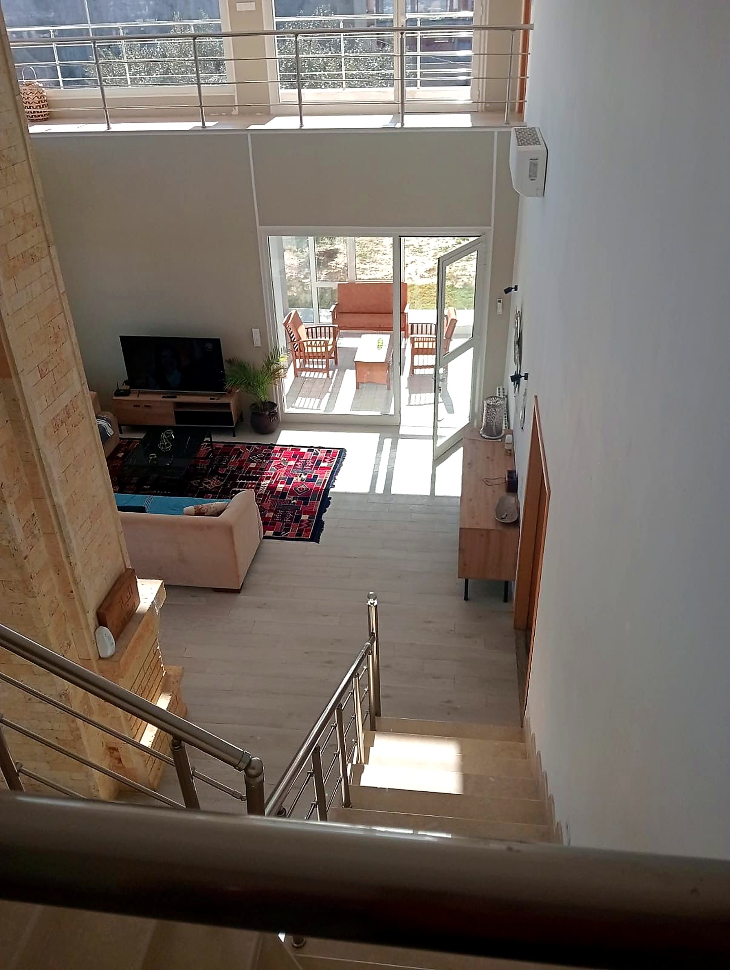 Double height salon seen from the staircase, opening onto the terrace