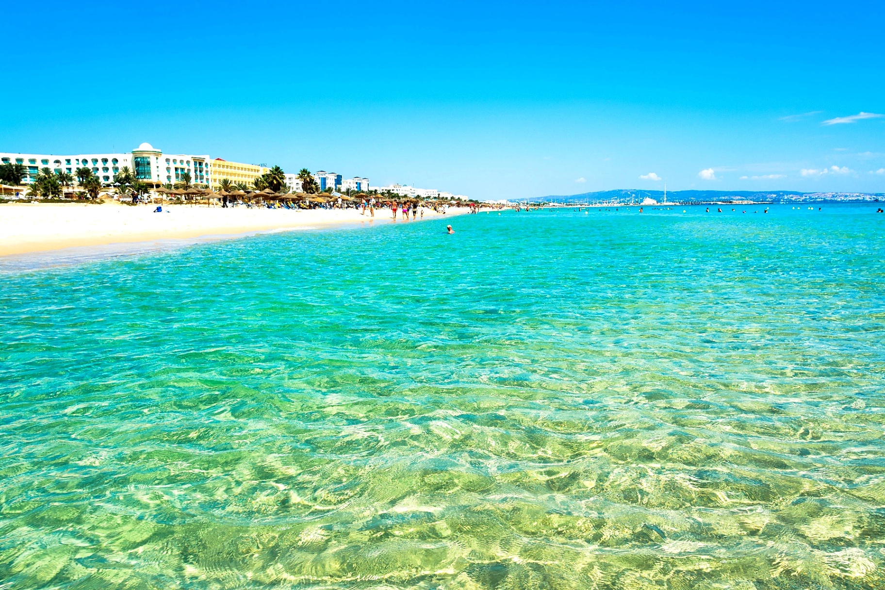 Turquoise shallow sea and white sand at Yassmine Hammamet beach