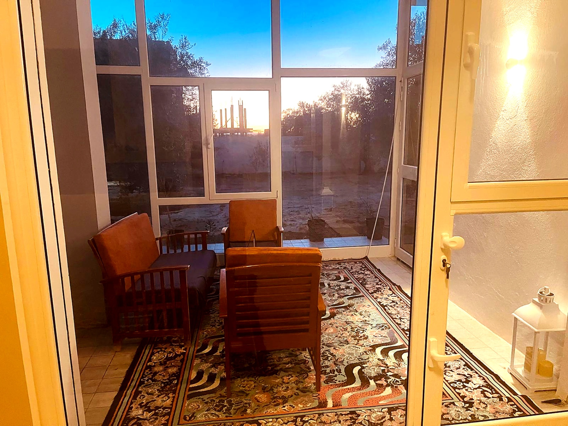 Winter garden lounge with wooden armchairs at sunset