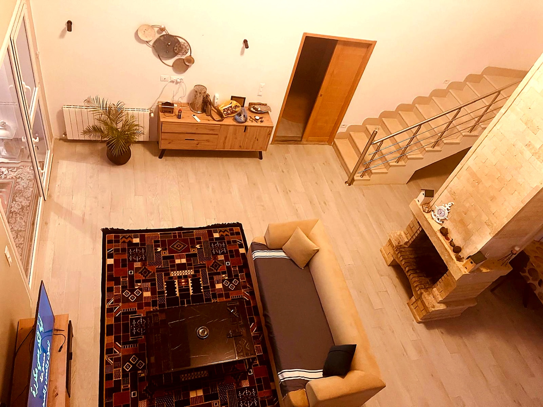 Living room seen from the mezzanine with Berber rug and fireplace