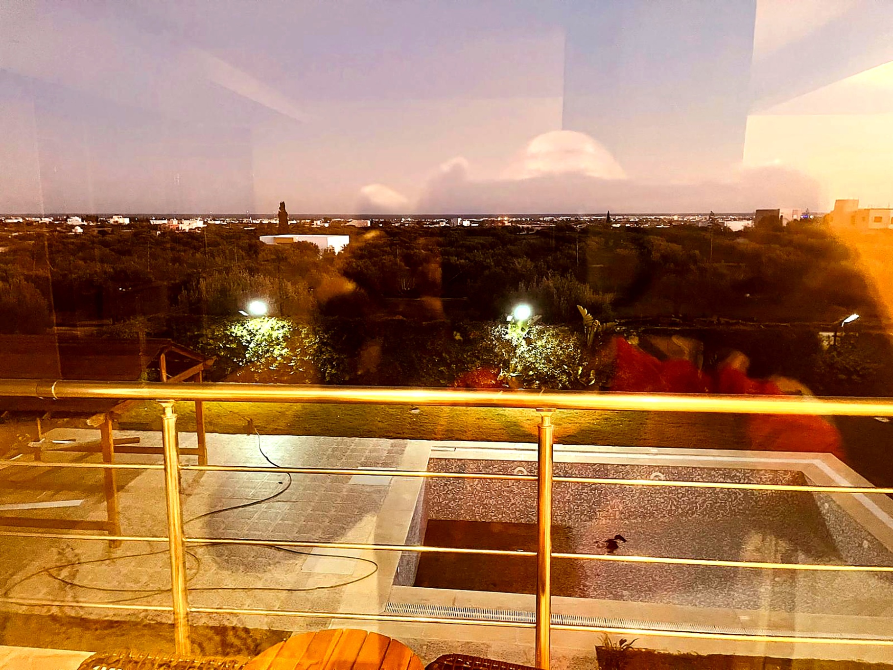 Swimming pool and countryside seen from the upper terrace at night