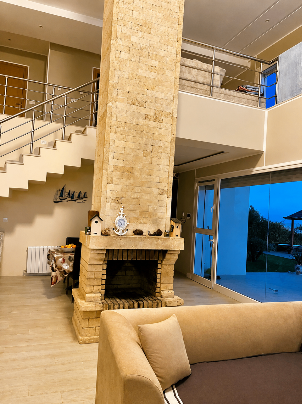 Double height salon with stone fireplace and staircase