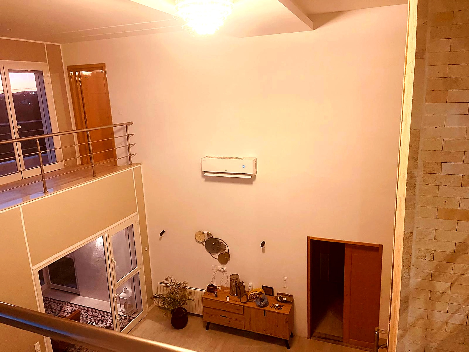Double-height entrance hall with mezzanine and travertine wall
