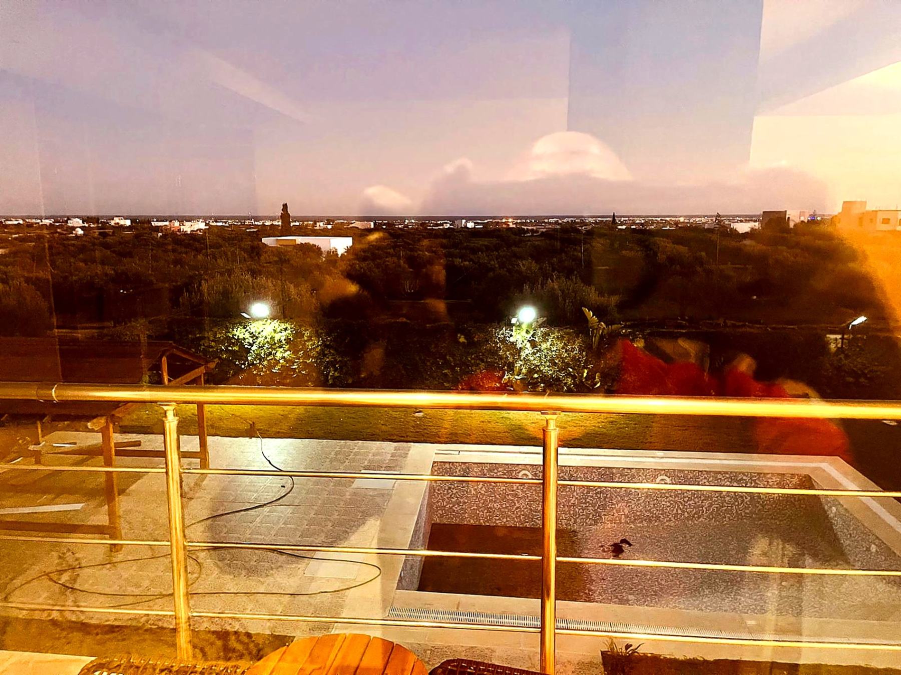 Swimming pool and countryside seen from the upper terrace at night